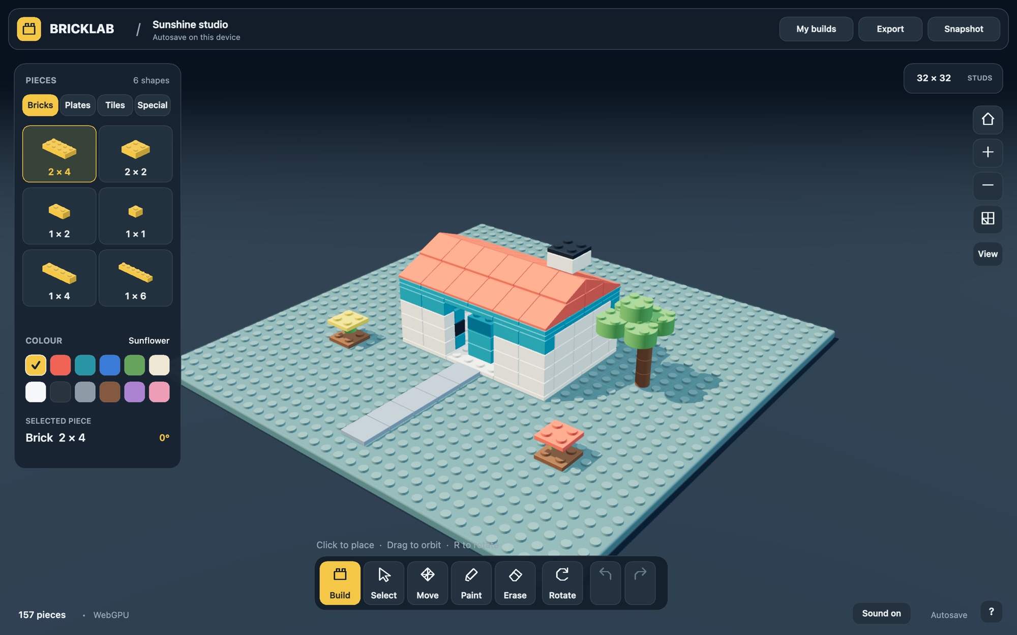 The Bricklab studio showing the Sunshine studio starter build: a white house with a coral roof, a tree and a stone path on a teal stud plate, with the piece catalog on the left and the tool bar along the bottom.